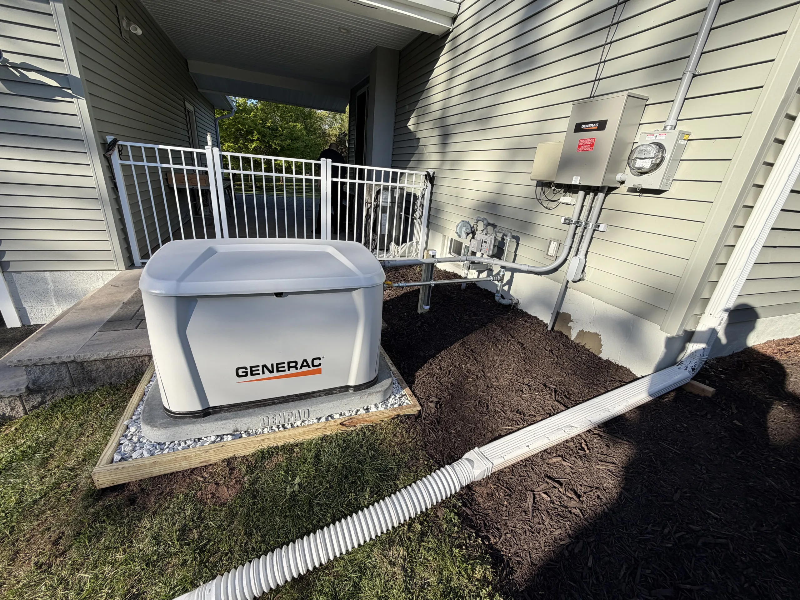Standby generator with conduit connection beside a home