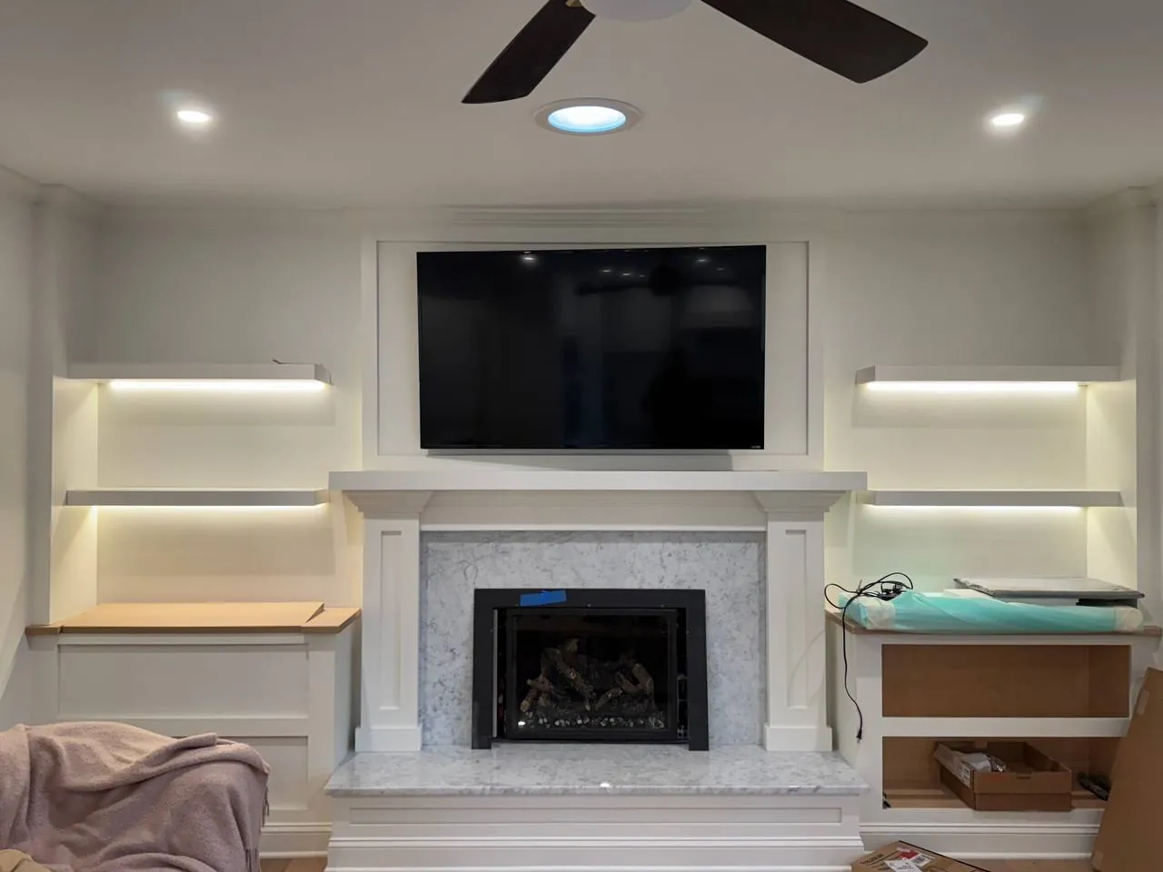 Living room with TV wall and LED shelf lighting